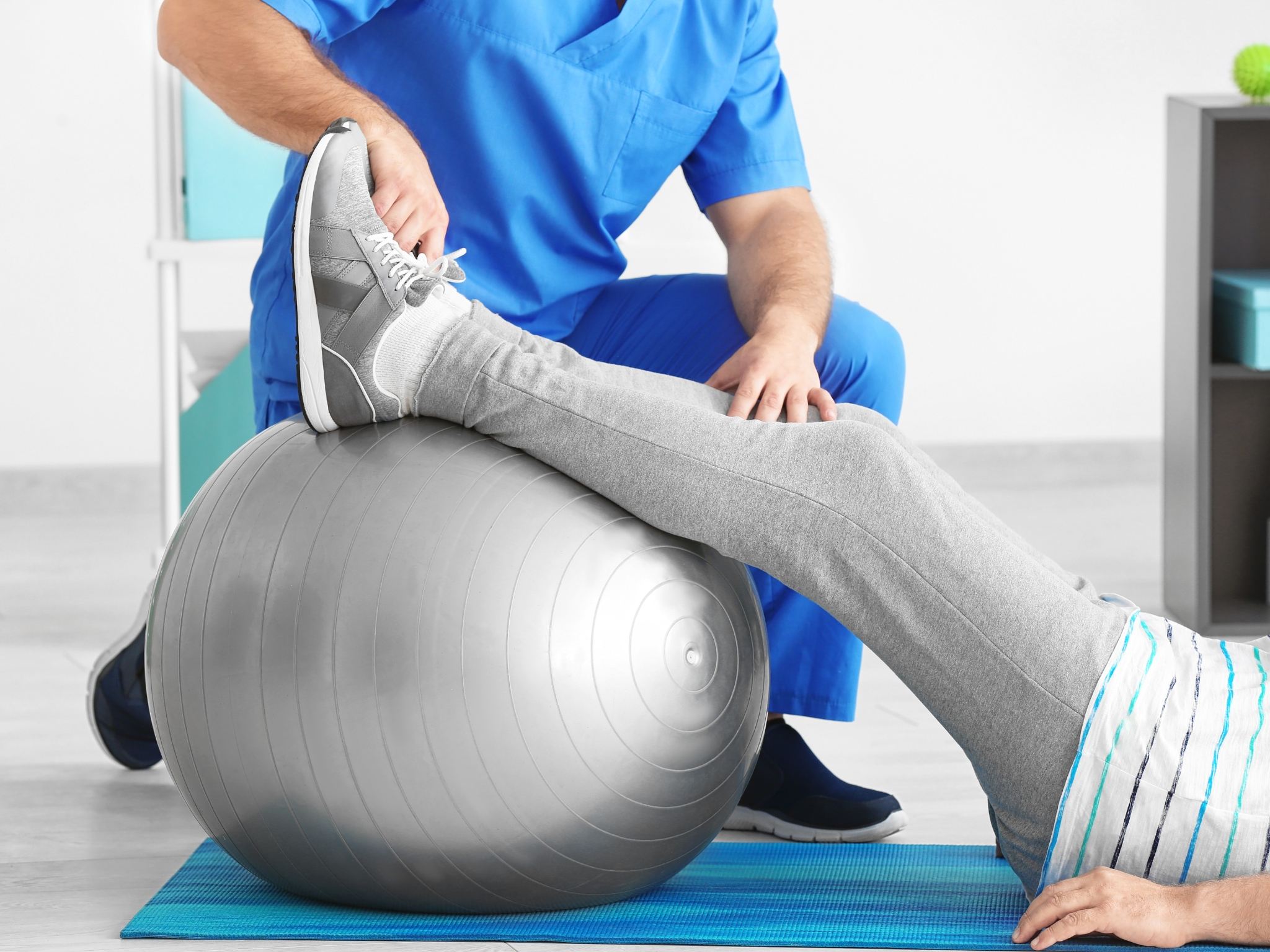 Paziente che esegue esercizi di rinforzo e rieducazione posturale sotto la supervisione di un esperto in fisioterapia a Perugia.